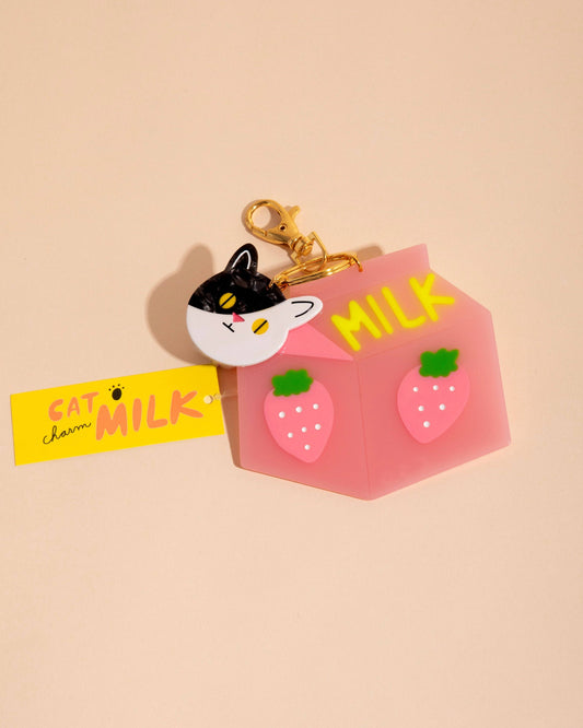 Keychain with a cat design and 'Milk' text on a beige background