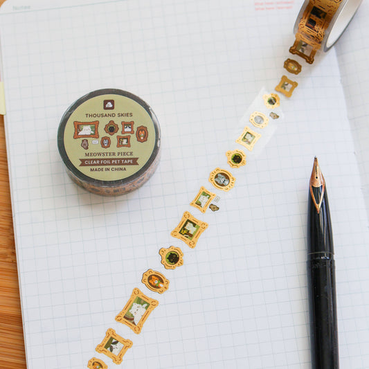 Decorative tape with gold and green designs on a notebook page with a pen.