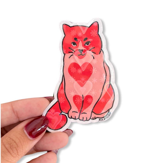 Sticker of a red cat with heart patterns held by a hand on a white background