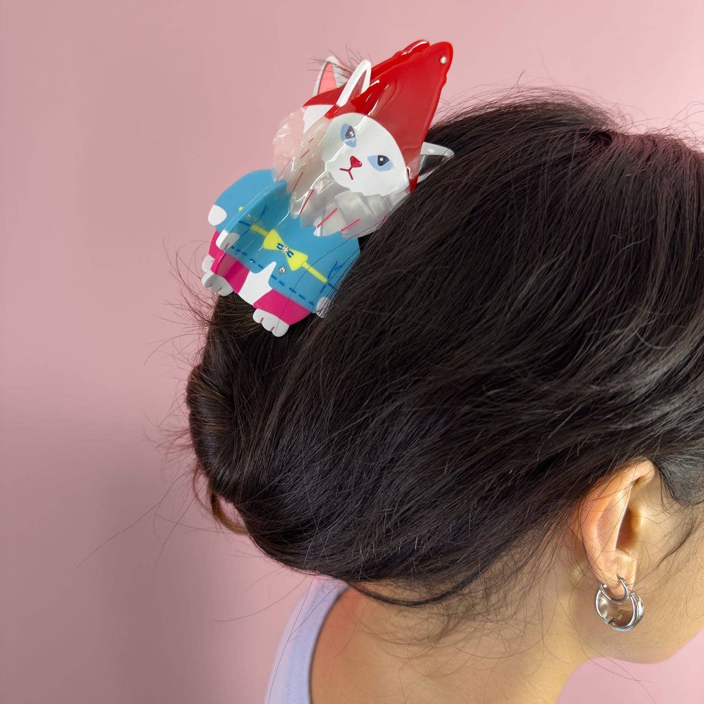 Hair clip with cartoon cat design on a pink background