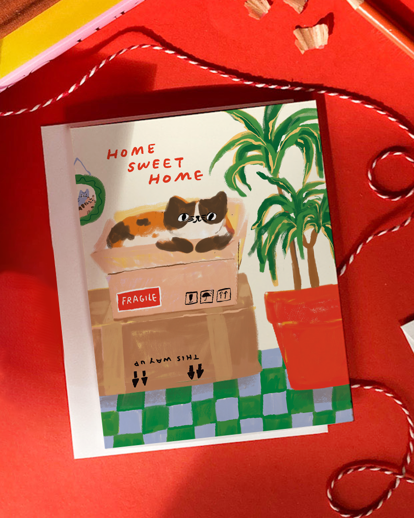 Card with a cat in a box and 'Home Sweet Home' text on a red background