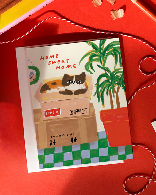 Card with a cat in a box and 'Home Sweet Home' text on a red background