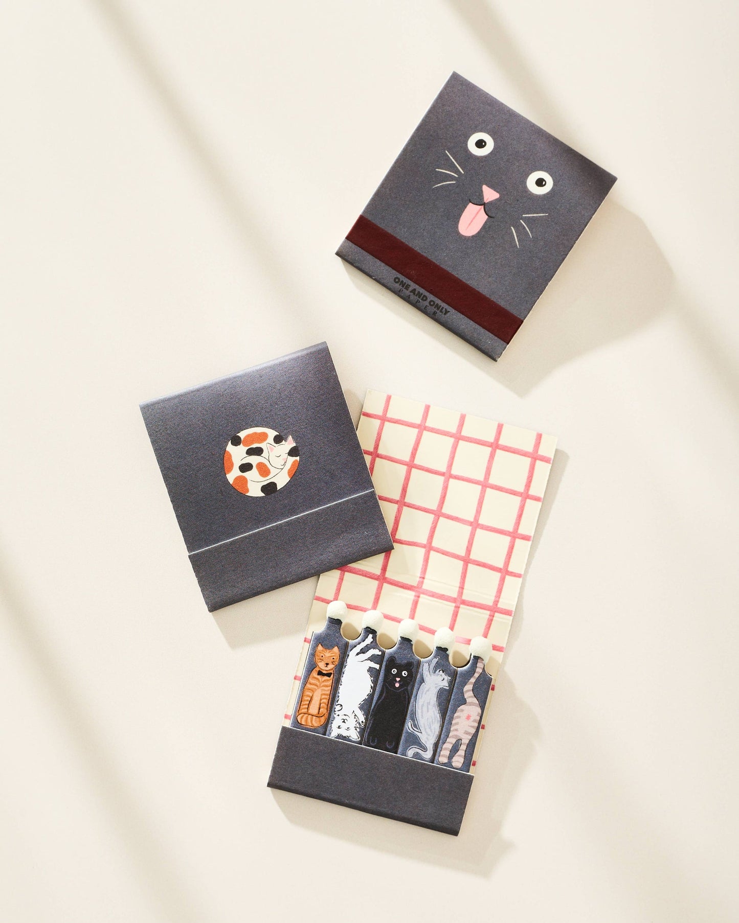 Three small boxes with cat-themed designs on a light background