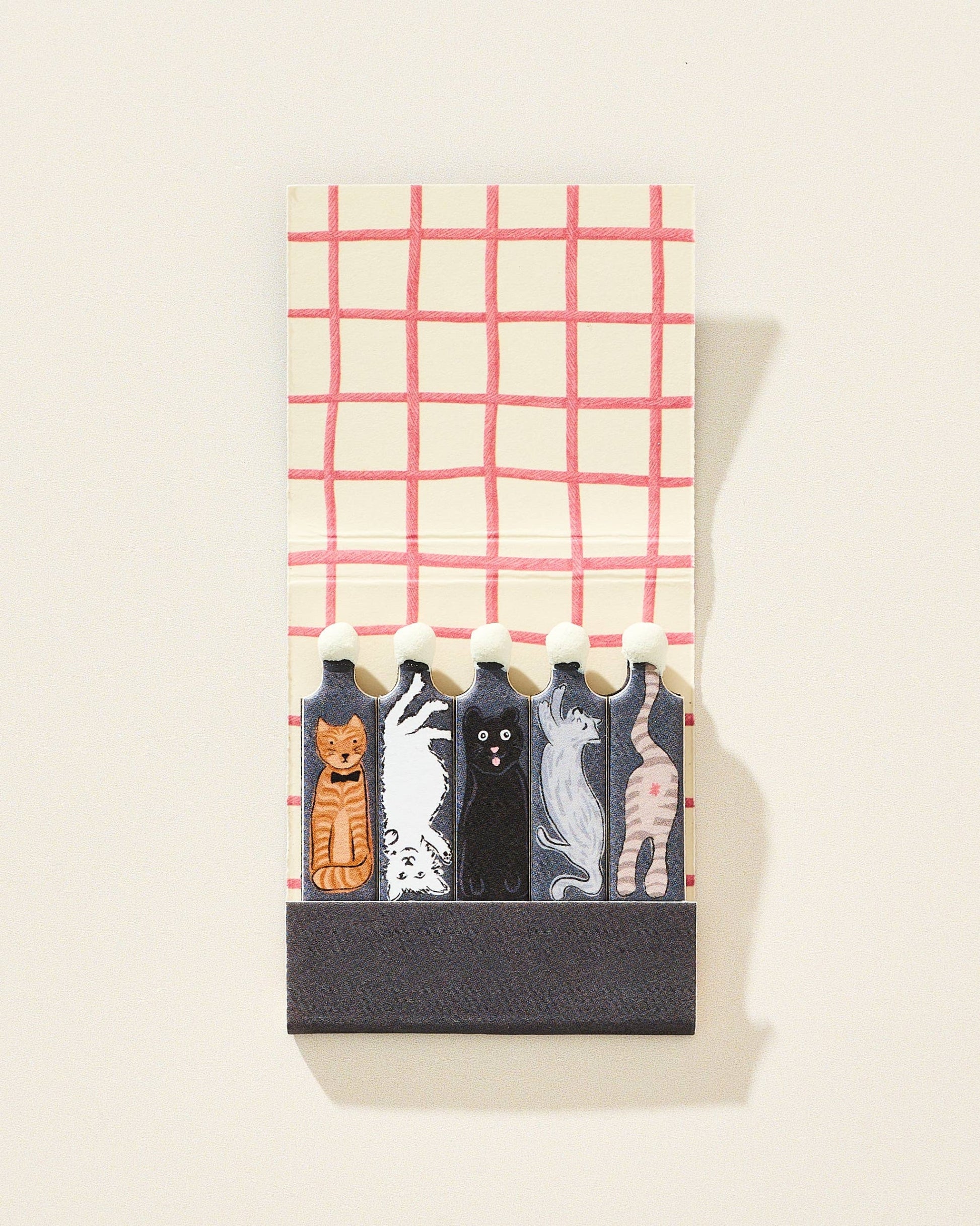 Set of cat-themed matches in a decorative holder with a plaid pattern on a white background.