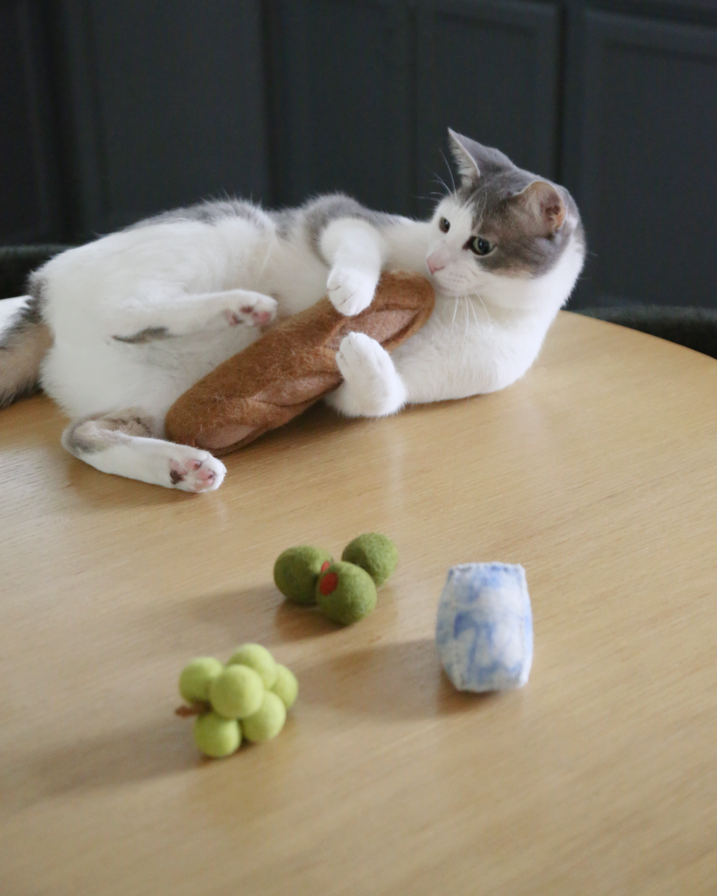 Cat playing with a toy on a wooden table