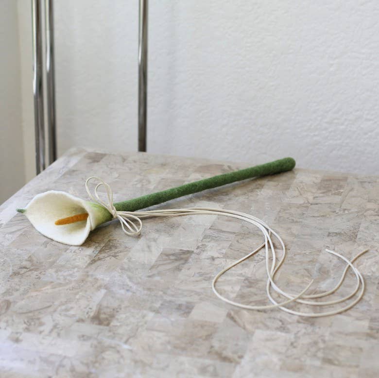 Calla lily flower on a marble surface with a neutral background