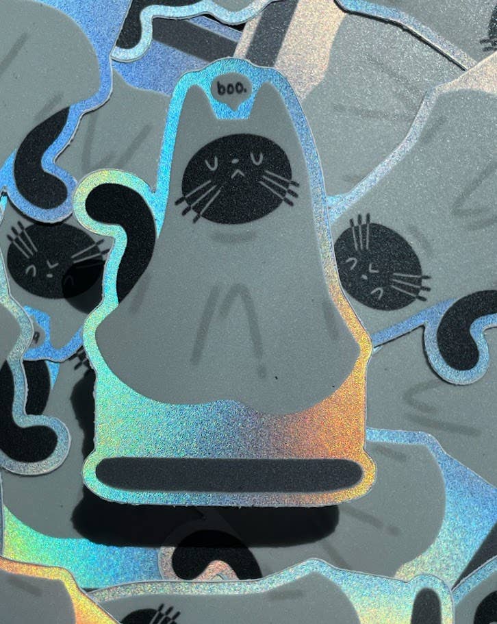 Holographic ghost sticker with black cat face design on a gray background