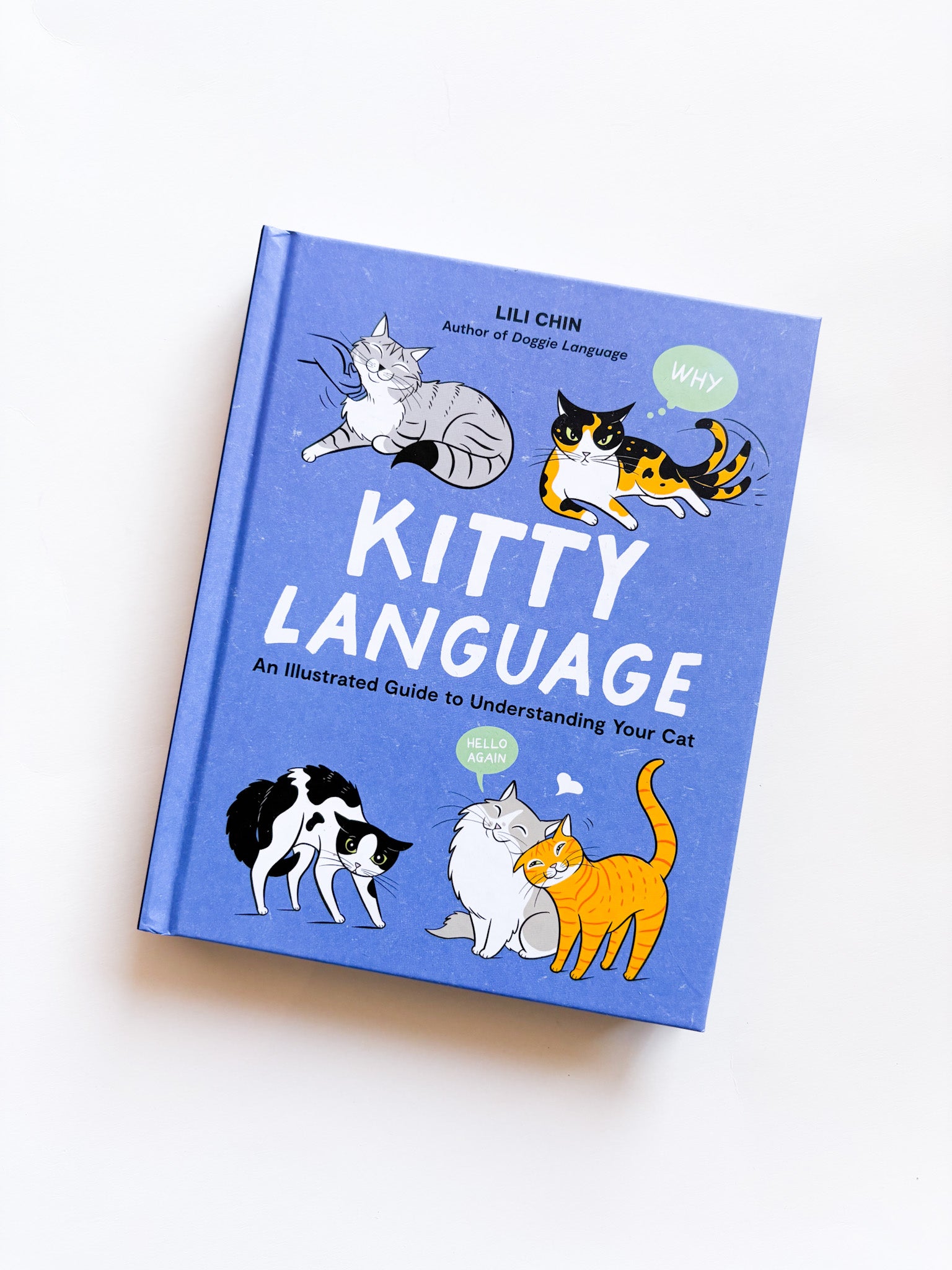 Book titled 'Kitty Language' with cat illustrations on a white background