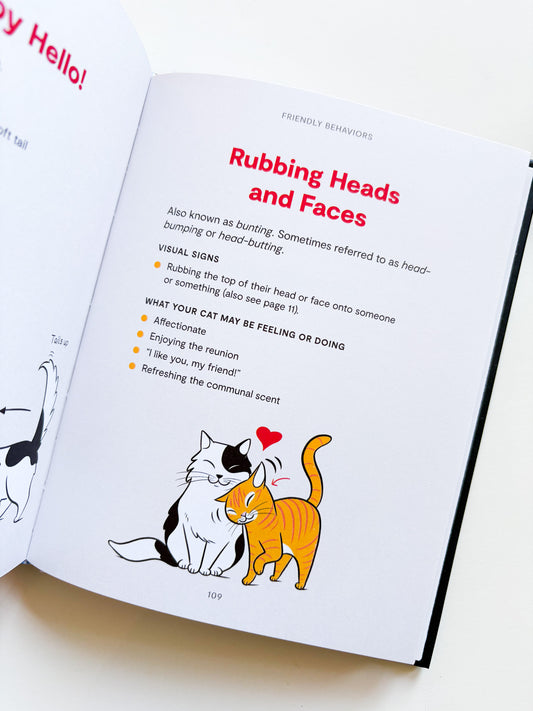 Book page about cat behavior with illustrations of two cats and text on a white background