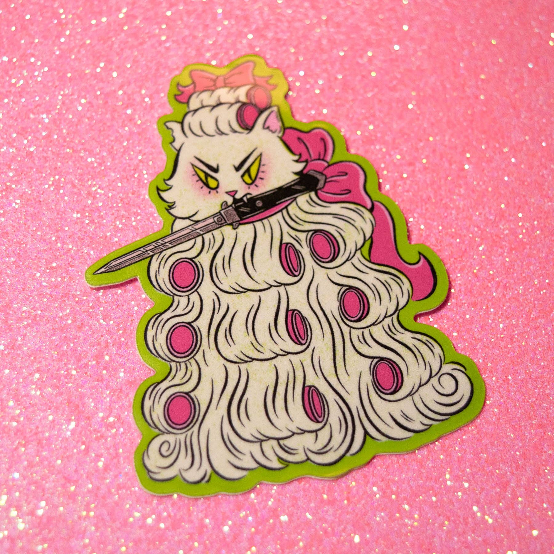A die-cut sticker or pin featuring an anime-style white cat with yellow eyes, holding a katana, dressed in a long white wig with pink circular accents and a pink bow, set against a pink glitter background.