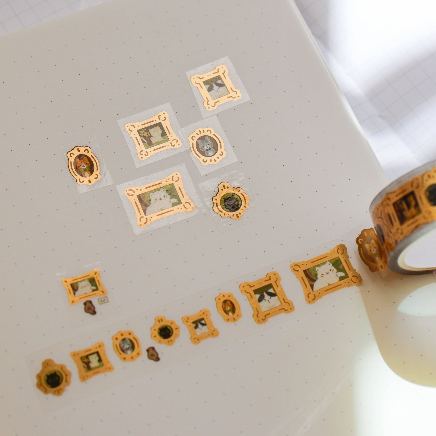Decorative washi tape with small framed stickers on a notebook page