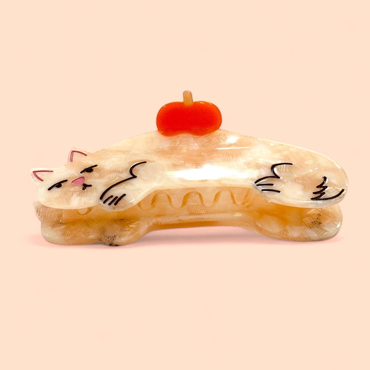 Cat-shaped soap with a pumpkin on top against a beige background