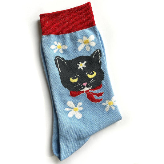 Sock with a black cat design, red band, and white flowers on a light blue background