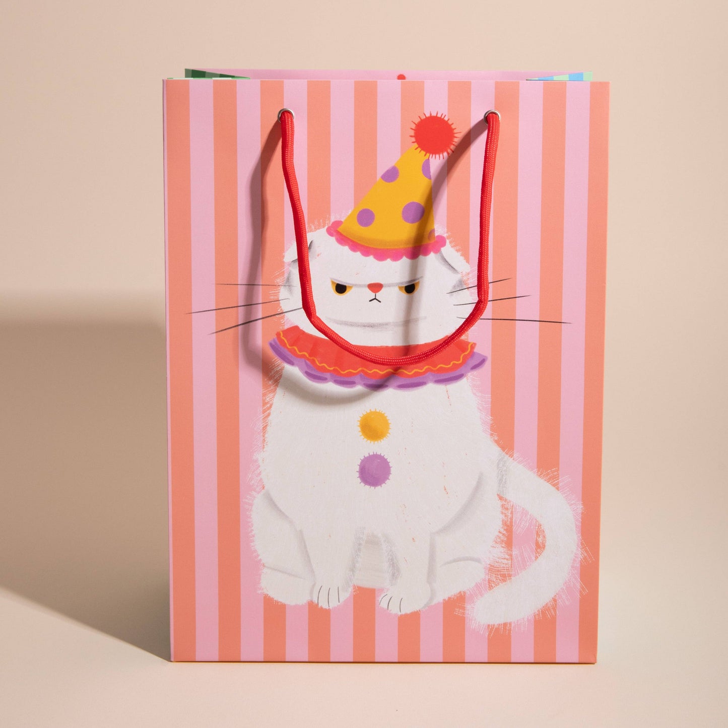 Gift bag with a cat design wearing a party hat on a striped background