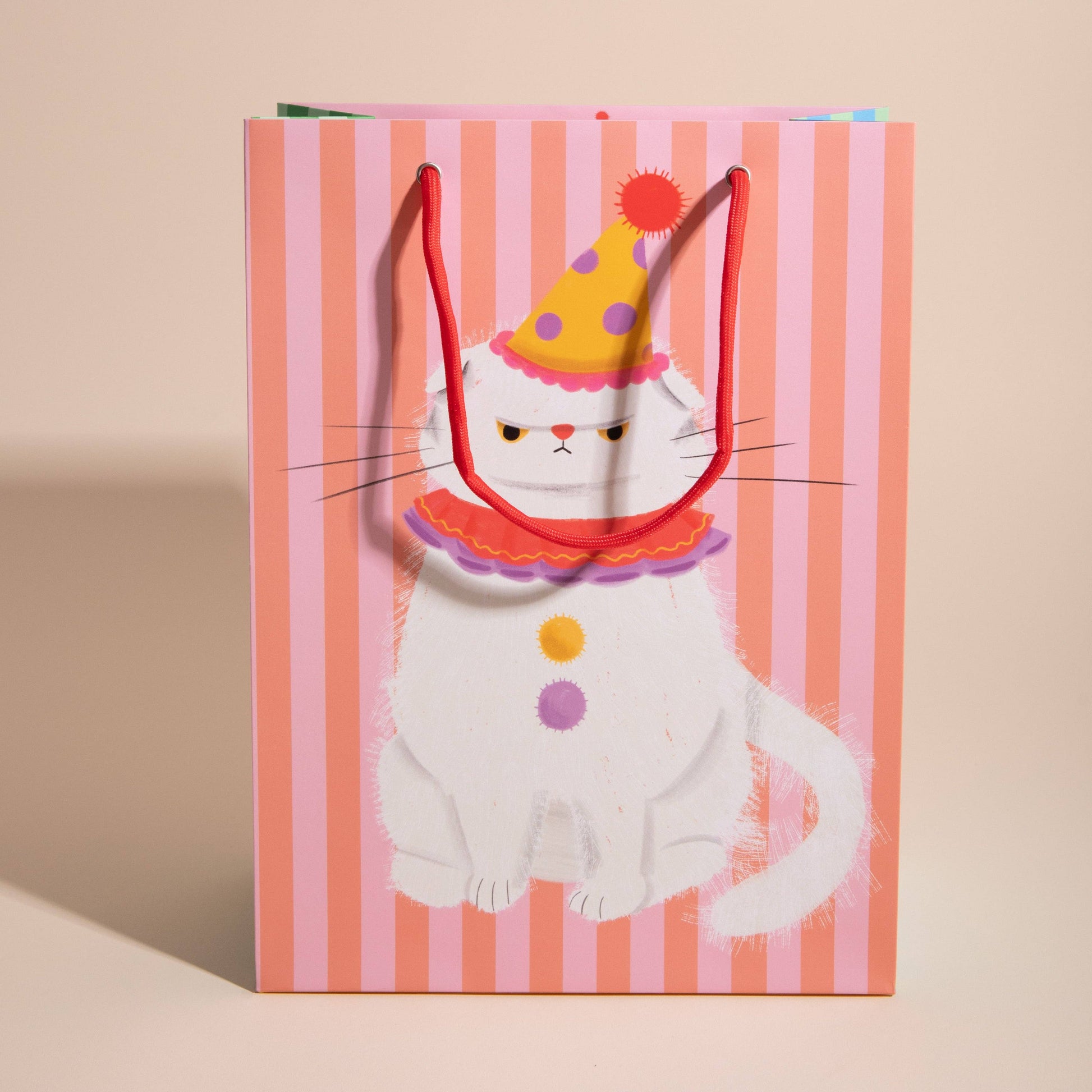 Gift bag with a cat design wearing a party hat on a striped background