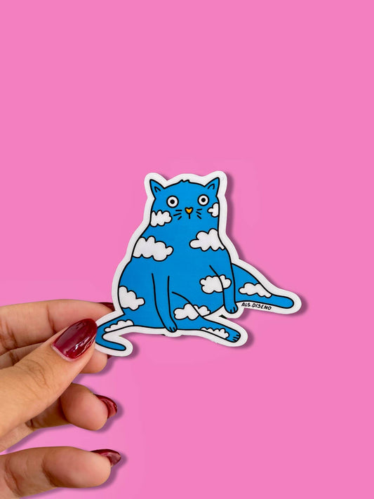 Blue cat sticker with white clouds held by a hand against a pink background