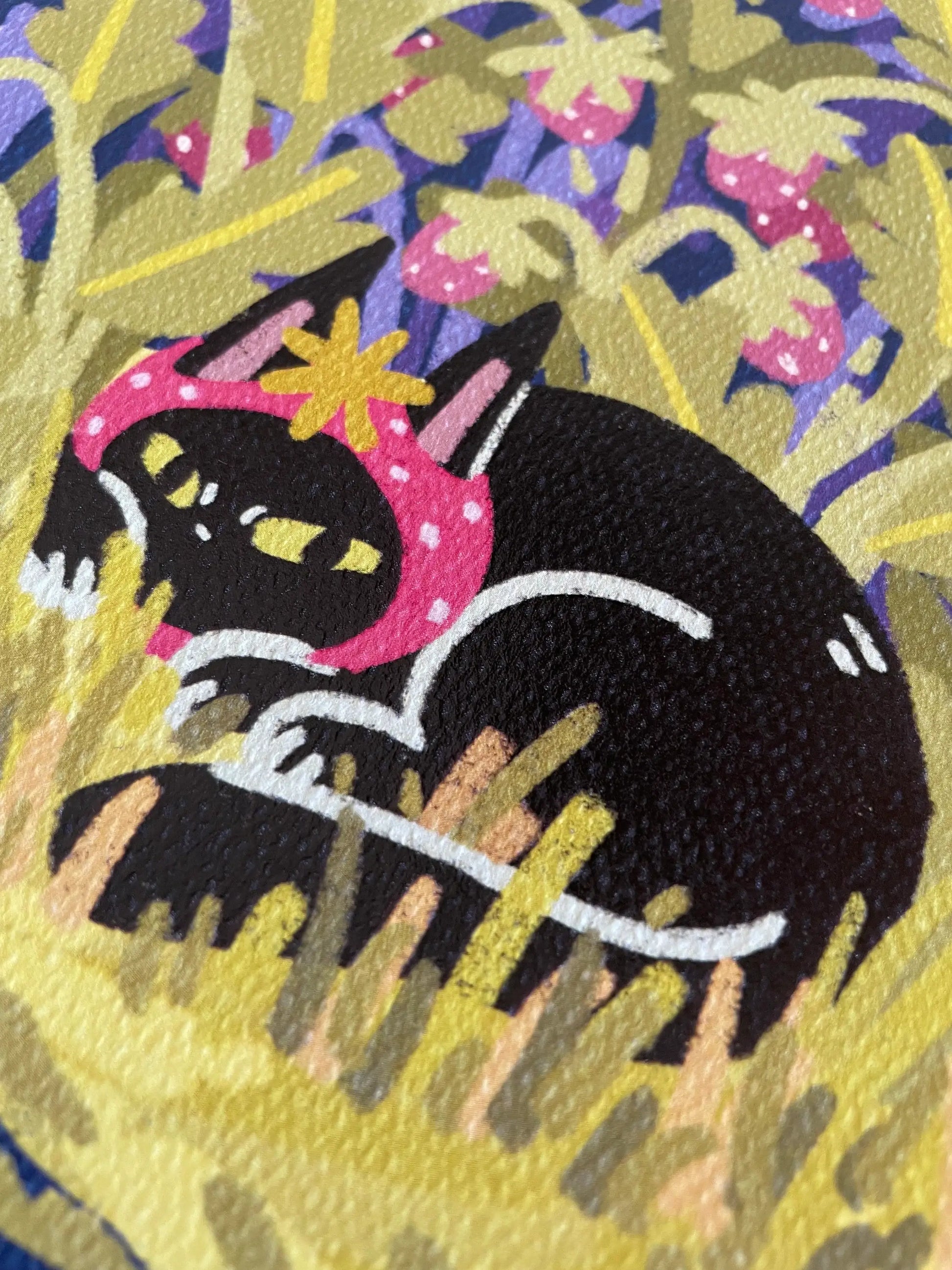 Embroidered patch of a black cat with a pink headband on a floral background