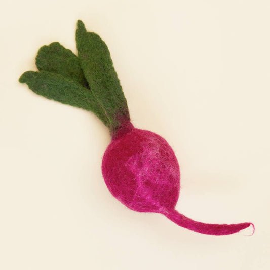 Felted pink radish with green leaves on a beige background